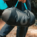 Person carrying a black HydraPak 8 litre expedition water storage bladder by the flexible handle