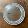 Close up direct overhead view of HydraPak Recon leakproof Flat Cap to convert 500 ml, 750 ml and 1 litre Recon bottles into a wide mouth bottle for water or dry food storage.  Colour: Clear. 