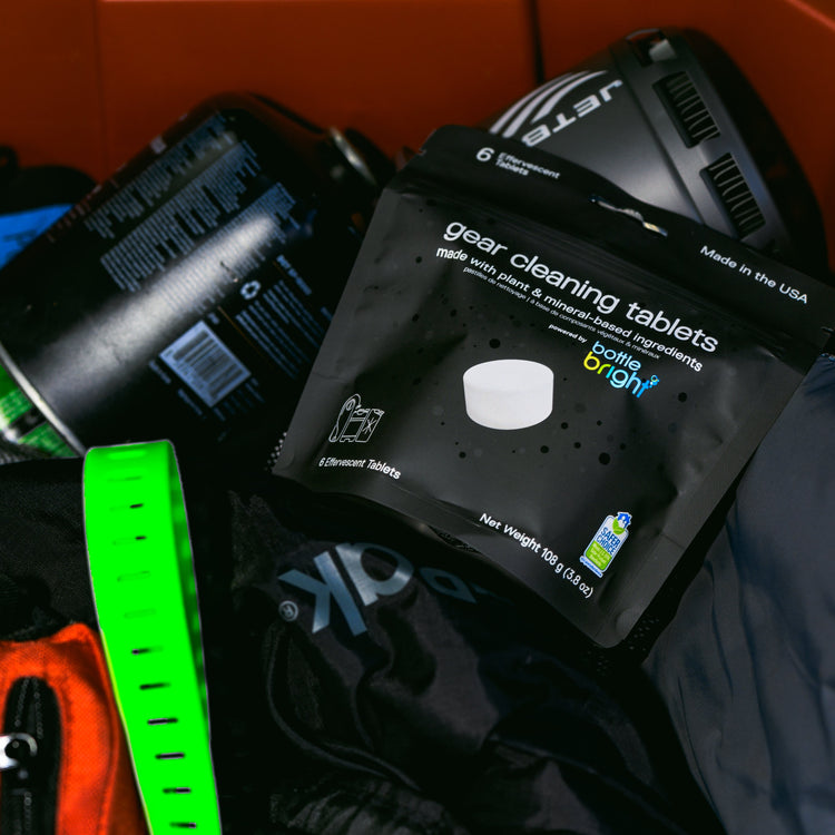 Packaging of Bottle Bright  gear cleaning tablets with a green and black equipment in the background.
