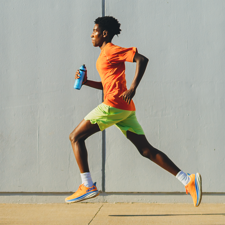 Person holding the HydraPak Tempo Pro 525ml using the handle while out running. Colour: Blue  