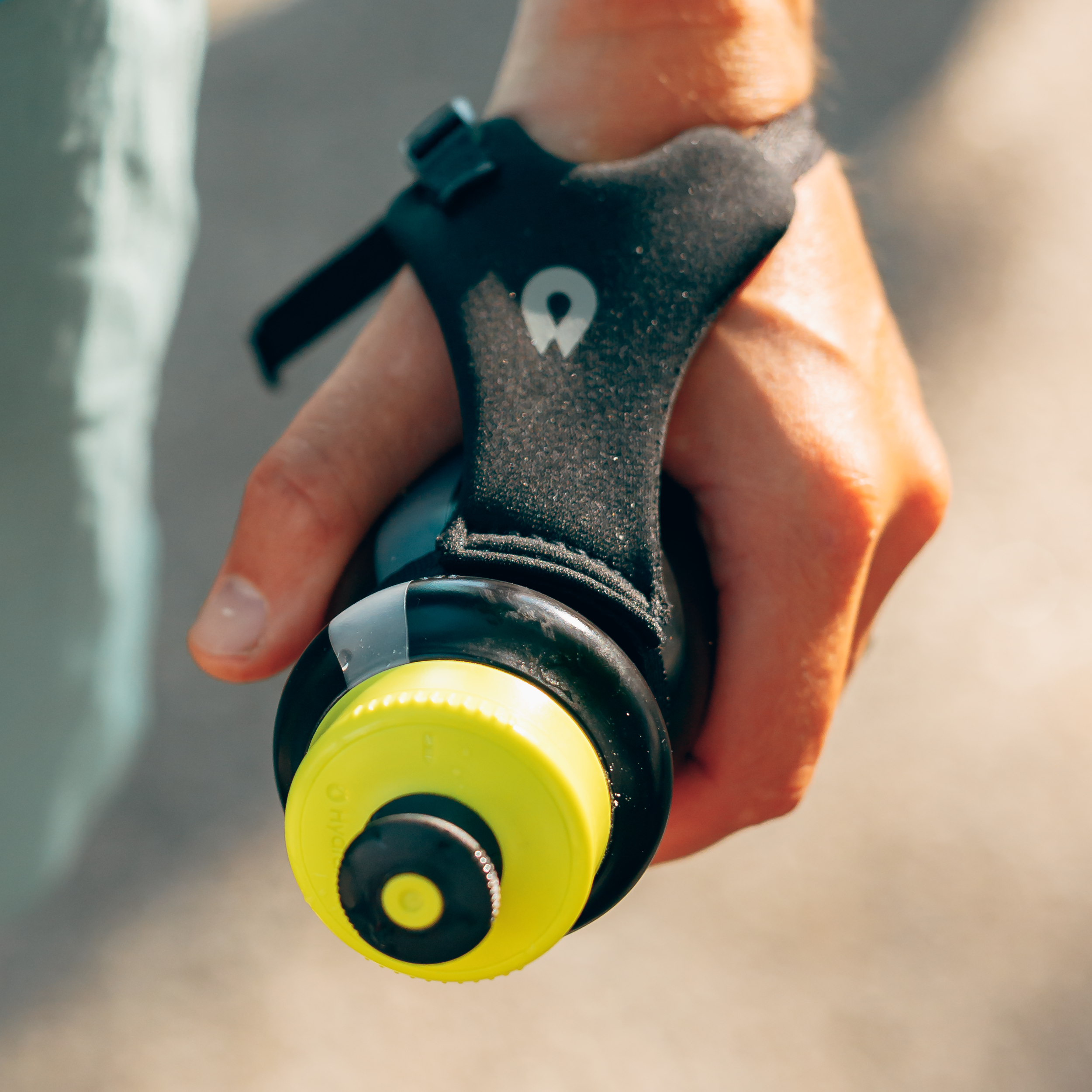 Person holding the HydraPak Tempo Pro 525ml using the handle while outside. Colour: Black 